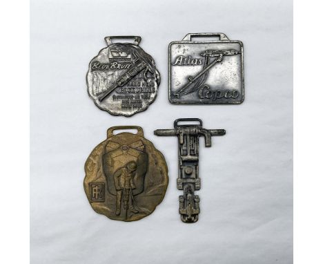 Metal finish with embossed design and lettering. First fob front view: Blue Brute Hand Held Rock Drills; reverse side: Blue B