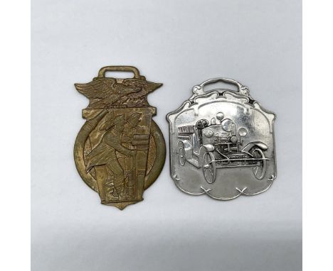 Metal finish with embossed design and lettering. First fob, brass-color finish, front view: depicts in an embossed image of t