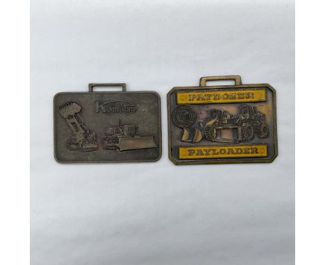 Metal finish with embossed design and lettering. First fob front side: Komatsu; reverse side: Komatsu Manufacturing Co. Ltd. 