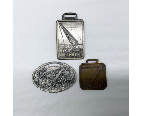 Metal finish with embossed design and lettering. First fob, tall rectangular shaped, front side: Northwest; reverse side: Sta