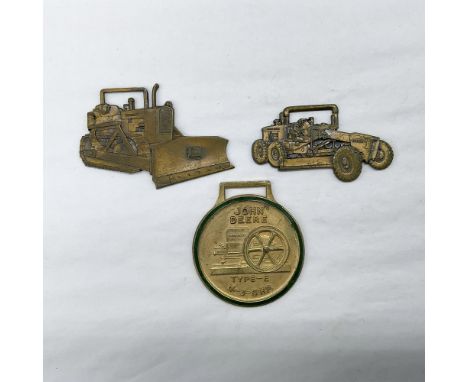Metal finish with embossed design and lettering. First fob front view: shaped as a bulldozer with the John Deere logo on the 