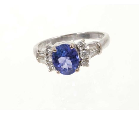 Tanzanite and diamond ring with an oval mixed cut tanzanite estimated to weigh approximately 1.1cts, flanked by six round bri