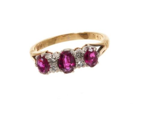 Ruby and diamond ring with three oval mixed cut rubies and four single cut diamonds in gold claw setting on 18ct yellow gold 