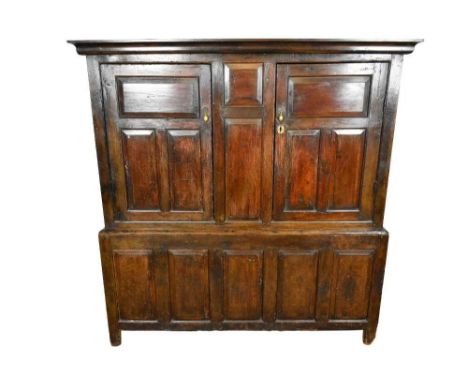 Very large mid 18th century panelled oak and pine two height cupboard, with cavetto moulded cornice and enclosed by two field