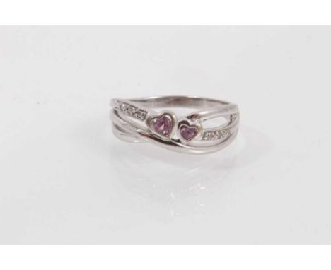 Diamond and pink sapphire ring with two heart shaped pink sapphires and diamond set shoulders in triple band cross over setti