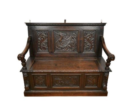 Victorian carved oak box settle, triple panel back and hinged seat over conforming frieze flanked by arms with mask terminals