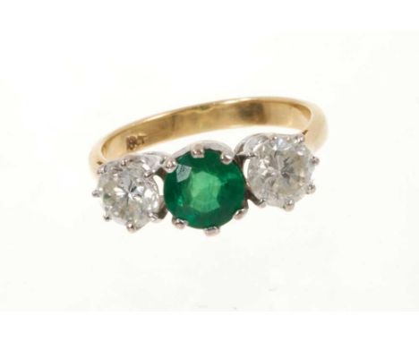 Emerald and diamond three stone ring with a round mixed cut emerald estimated to weigh approximately 0.85cts flanked by two r