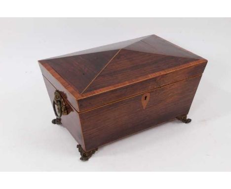Regency rosewood and satinwood crossbanded sarcophagus shape tea caddy, with flanking ring handles and enclosing twin lidded 