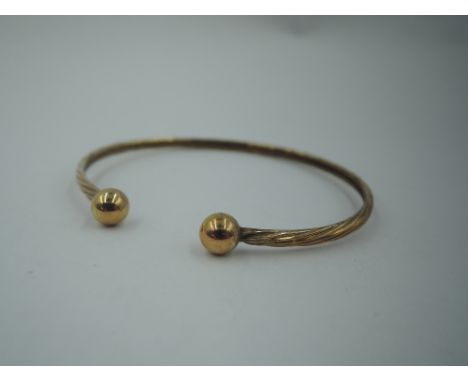 A 9ct gold tension bangle having ball knops, approx 3.4g&nbsp;