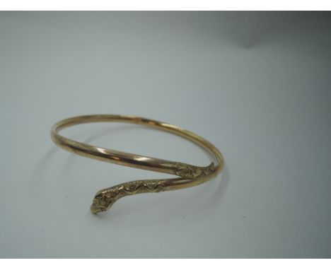 A 9ct gold snake bangle having paste eyes and moulded decoration to head and tail, approx 5.4g