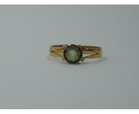 A 22ct gold composite ring having an added peridot stone in rose metal collared mount, size U and approx 3.2g