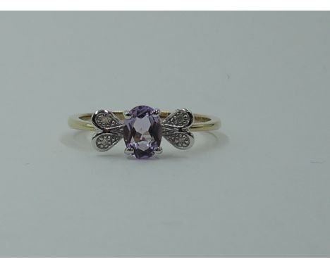 An amethyst dress ring having diamond chip decoartive panels to shoulders on a 9ct gold loop, size P and