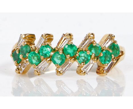 An 18 carat gold, emerald and diamond ring, with ten round cut emeralds mounted in pairs and flanked by ten baguette cut diam