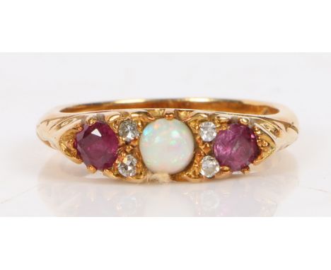 An 18 carat gold, opal, diamond and ruby ring, the central round opal flanked by four diamond chips and two round facet cut r