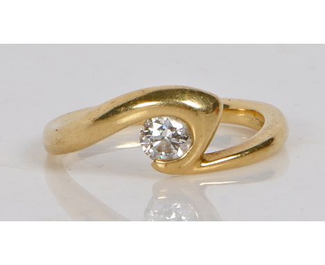 An 18 carat gold and diamond solitaire ring, the crossover band set with a single round brilliant cut diamond, ring size M, 4