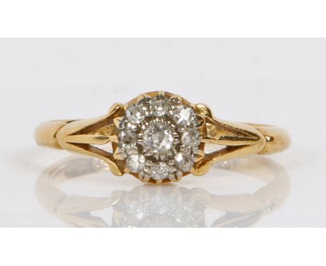 An 18 carat gold ring set with a central diamond surrounded by a band of eight diamond chips, ring size J, 2.2g