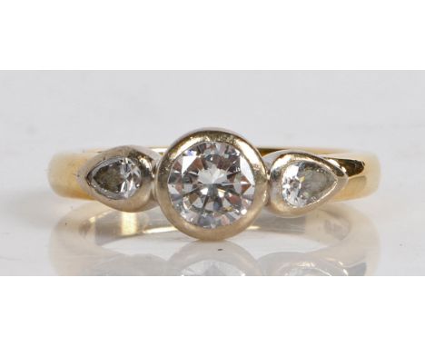 An 18 carat gold and diamond ring, the central round brilliant cut diamond flanked by two teardrop diamonds, ring size K 1/2,