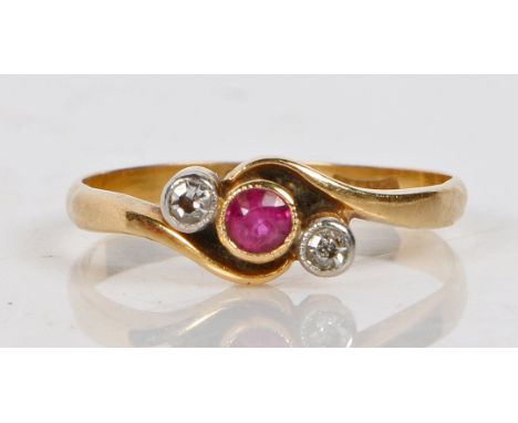 An 18 carat gold, ruby and diamond ring, the scrolled head set with a central ruby flanked by two diamonds, ring size N, 1.8g