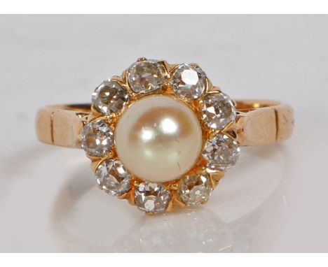 A yellow metal pearl and diamond ring, with central pearl surrounded by nine diamonds, the pearl measuring 6.5mm diameter, ri