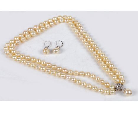 A cultured pearl necklace, formed from two rows of graduated pearls terminating in a 14 carat white gold and diamond set clas