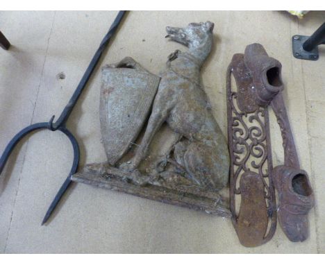 Cast iron doorstop in the form of a Tall grey hound seated with a paw upon a shield along with a Boot scraper and a Bale fork