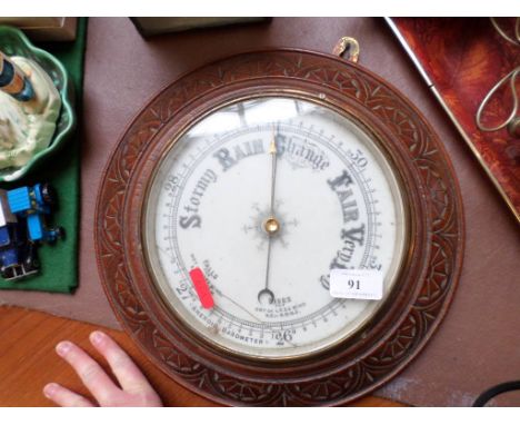 Steel dialled aneroid barometer in circular carved oak case 