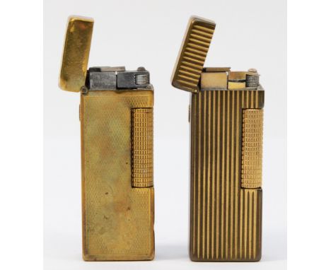 Alfred Dunhill; Two Dunhill rollagas pocket cigarette  lighters, gold plated having ribbed and engine turned decoration. (2)