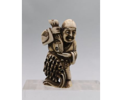 NETSUKE: FISCHER / Japanische Schnitzfigur, Asien / Japan, Bein oder Horn, mit Signatur. Vollplastische Darstellung eines ste