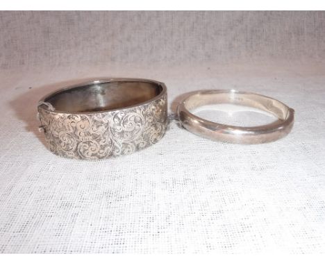 A SILVER BANGLE, with safety chain and one other similar bang (2)