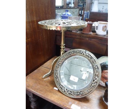 A 19TH CENTURY BRASS FRAMED MIRROR with strut support and a 19th century brass trivet in the shape of a wine table (2)