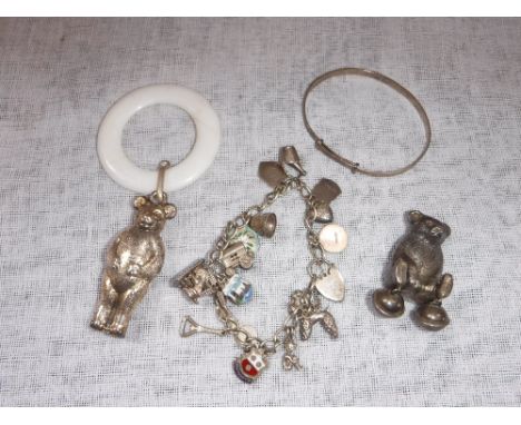 A SILVER CHARM BRACELET, a silver bangle and a teething ring