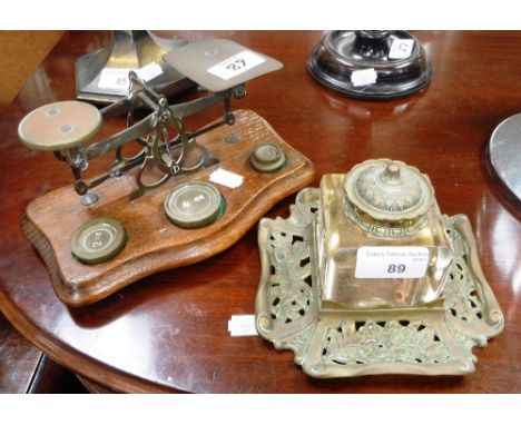 A VICTORIAN BRASS AND GLASS INKWELL ON STAND and a set of postal scales (2)