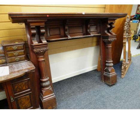 An early twentieth century carved mahogany fire surround with column supports & upper shelf, 138 x 195 x 32cms