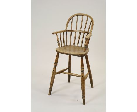 A child's ash wood high chair, 19th century, the hooped spindle back over a saddle seat and raised on four ring turned splaye