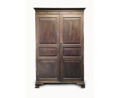 A George III mahogany gentleman's two door wardrobe, Channel Islands, circa 1800, the ogive cornice above two fielded panel f