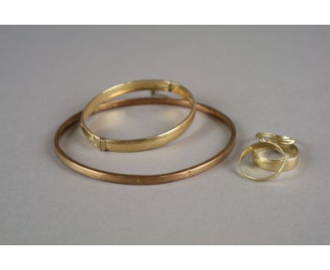 A 9ct gold hollow slave bangle, weight 6g, together with a gold plated bangle and three 9ct gold bands, weight 4.2g