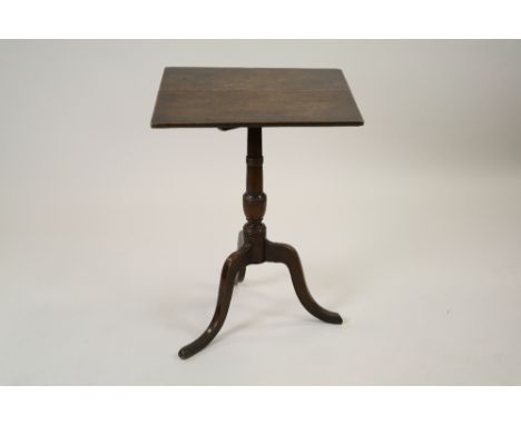 A George III oak tripod table, the rectangular tilt top raised on a slender vase shaped column and three down curved tapering