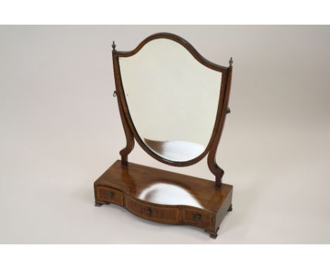 A George III mahogany and satinwood strung serpentine front toilet mirror with shield shaped plate and later bevelled insert,
