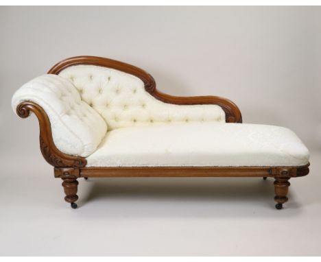 A mid Victorian mahogany framed scroll end chaise longue, later upholstered in  cream floral fabric with button down end and 