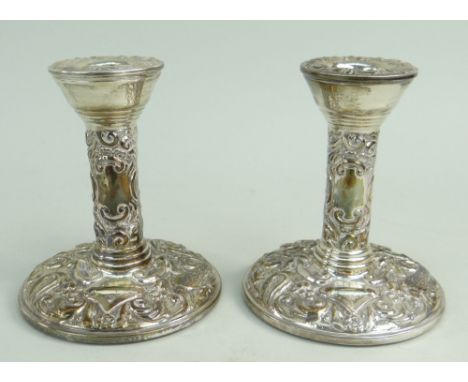 PAIR OF FILLED SILVER DWARF CANDLESTICKS of circular shape featuring bird and scroll repousse decoration. Birmingham 1975, Br