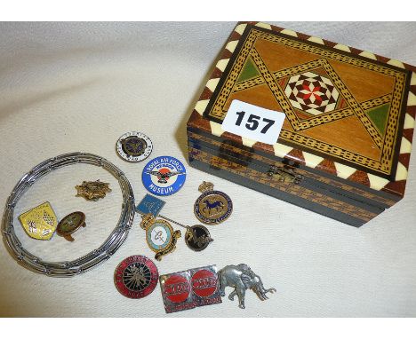 Old enamel badges in an inlaid box, inc. military, car, road and cycle clubs. Together with a pair of gents sleeve garters
