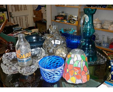 Collection of assorted coloured glassware including hall light shades, advertising milk bottles, bowls and vases