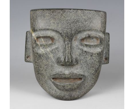 A pre-Columbian Teotihuacan style carved green hardstone mask, probably 250-700AD, with pierced ears and sides, bearing colle