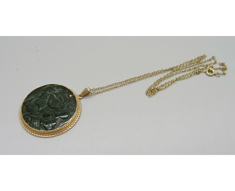 A 9ct gold mounted carved jade pendant and chain, 29mm diameter, 10g 