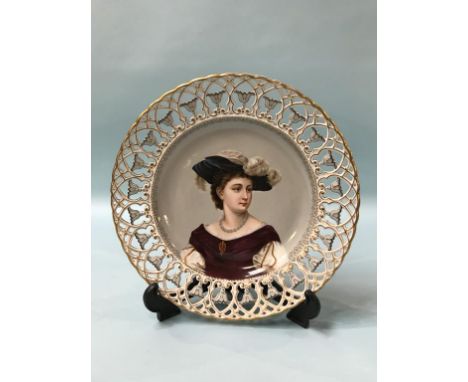 A German porcelain plate with pierced fretwork border, the centre decorated with a portrait of a lady, blue marks, 30cm diame