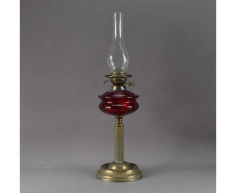 A 19th century oil lamp, the main shade missing, with a cranberry glass bowl, on a fluted column and circular base, 66cm high