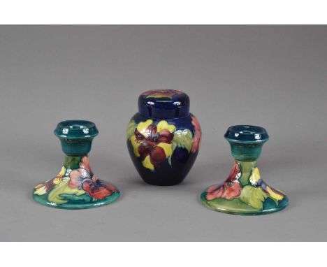 Three pieces of Moorcroft pottery, all first half 20th century, comprising a pair of dwarf candlesticks, both 9cm high, and a