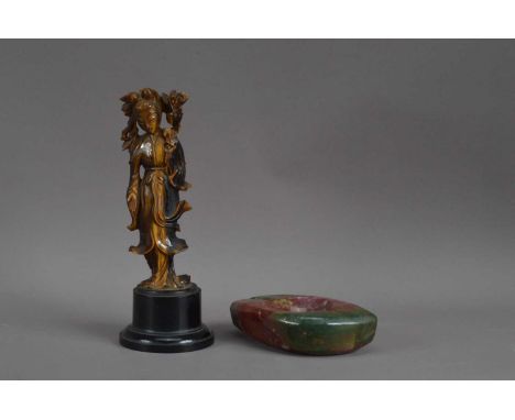 A Chinese carved tiger eye figure of Guanyin, cracked and restored around the head, on a circular plinth base 22cm high, toge