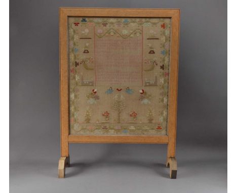 A framed 19th century sampler, in an oak fireguard frame, dated 1843, named indistinctly, frame size 86cm x 61cm