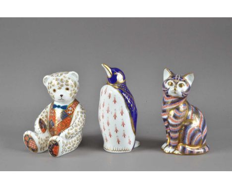 Three Royal Crown Derby bone china paperweights, comprising a teddy bear with silver stopper, a penguin with a gold stopper, 